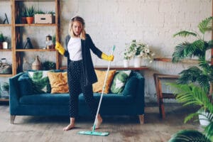 Frau hört Musik während Sie Ihre Wohnung wischt