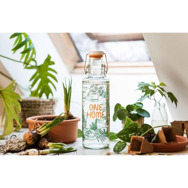 Soulbottle One Home (0,6 Liter) Glasflasche mit Bügelverschluss zwischen Pflanzen stehend