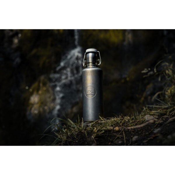 Soulbottle Steel Insulated Industrial (0,6 l) Edelstahl Thermosflasche vor einem Bachlauf stehend